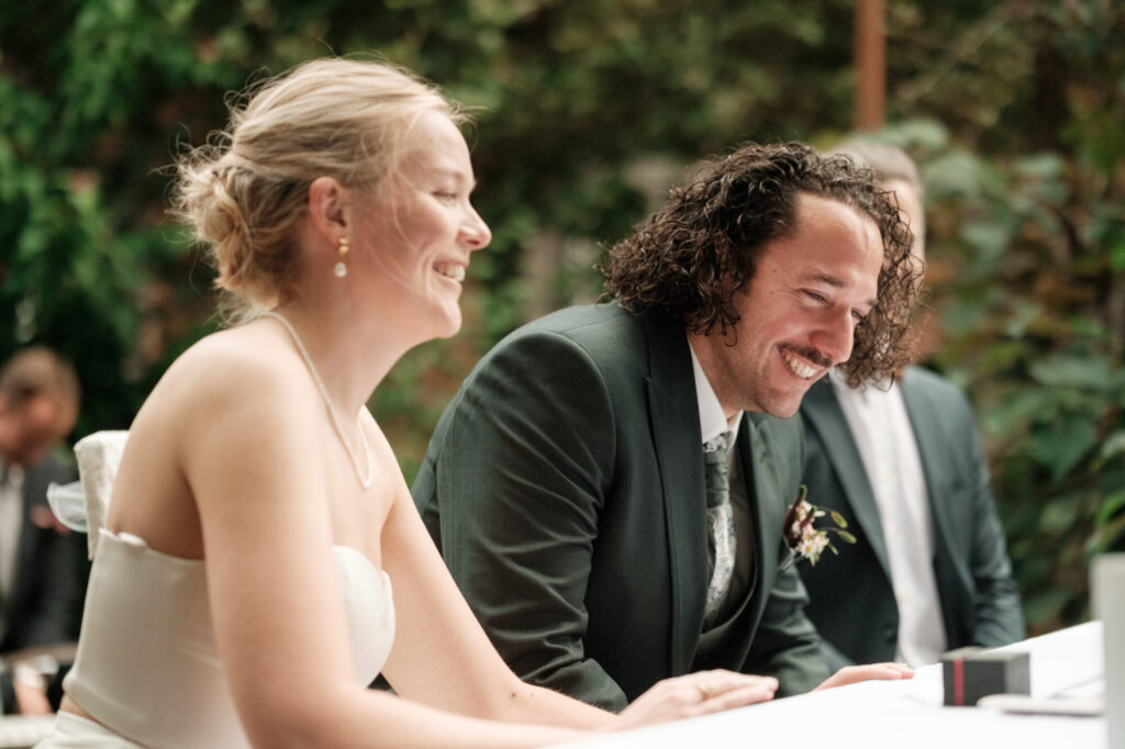 Brautpaar lacht bei der Unterschrift, Hochzeit Anne & Phil auf dem Hof Gottschalk in Helpsen