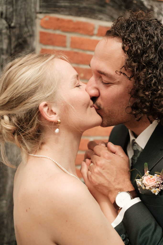Kuss am Fachwerkhaus, Hochzeit Anne & Phil auf dem Hof Gottschalk in Helpsen